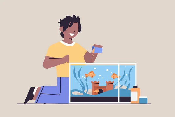 Africký americký chlapec krmení ryb v akváriu domácí zvířecí přátelství s pojetím domácího mazlíčka horizontální — Stockový vektor