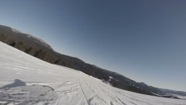 Snowboarder deslizándose por la colina — Vídeo de stock