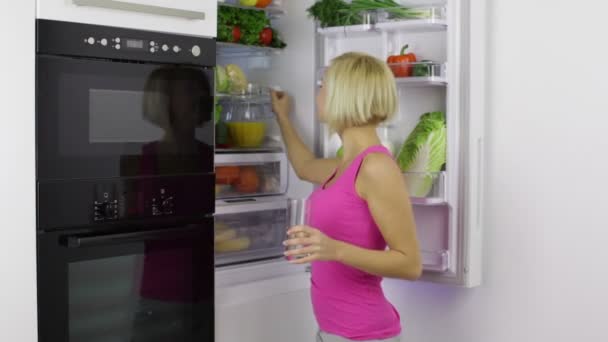 Женщина получает сок из холодильника — стоковое видео