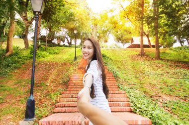 Asyalı kadın beni gülümseme yeşil park yol mutlu adam elini tutarak takip edin