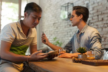 İki adam Internet teknolojisini kullanarak Tablet bilgisayar ve akıllı telefon