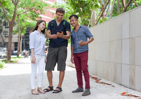 Asiático pareja ayuda turista celular inteligente caucásico hombre —  Fotos de Stock