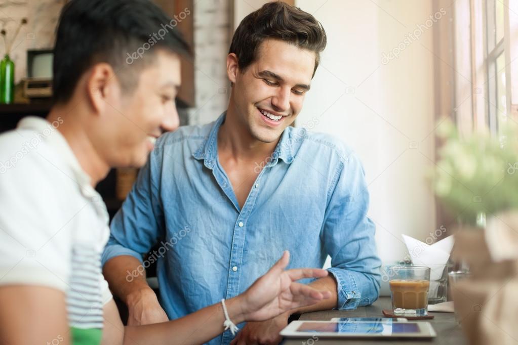 Men Using Tablet at Cafe