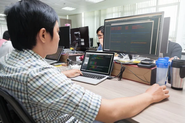 Desenvolvedor asiático usando laptop — Fotografia de Stock