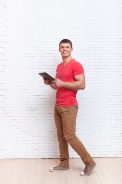 Tablet bilgisayar duvardan yürüyerek meşgul kullanan adam