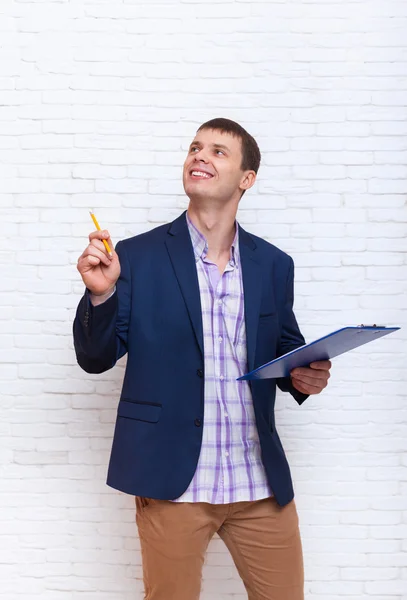 Junger Geschäftsmann hält Bleistift in der Hand, Geschäftsmann zeigt auf Kopierraum — Stockfoto