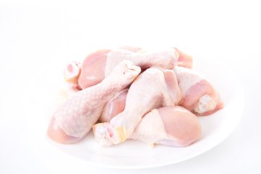 Beyaz arka planda çiğ tavuk budu.