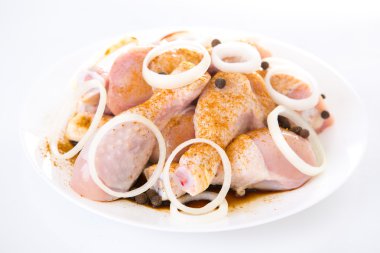 Beyaz arka planda çiğ tavuk budu.