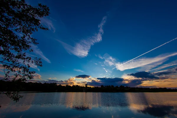 Голубое вечернее небо и гладкая поверхность воды — стоковое фото