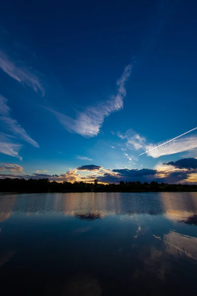 Blue evening sky and smooth water surface — Stock Photo, Image