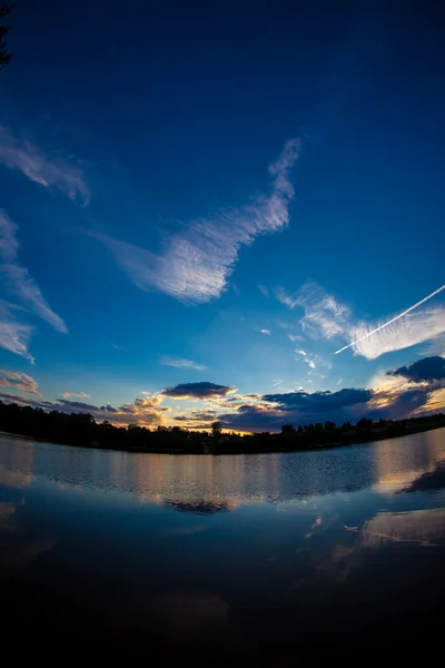 Cielo azul de la tarde y superficie lisa del agua — Foto de Stock