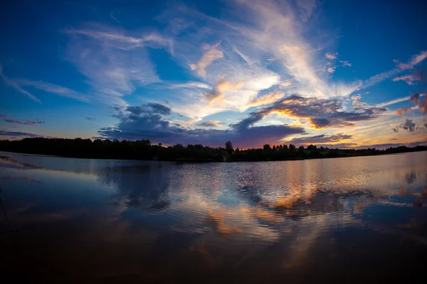 Ciel bleu du soir et surface de l'eau lisse Image En Vente