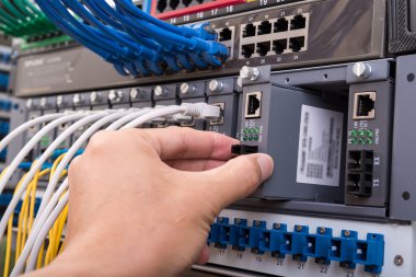 Dijital iletişim ve internet için fiber optik merkezi olan ağ sunucu odasında çalışan adam