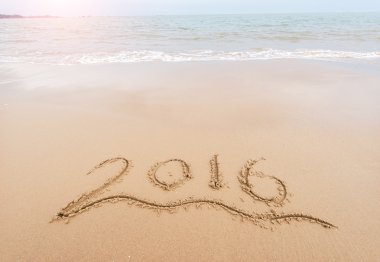 Yıl 2016 el denizin önünde beyaz kum üzerinde yazılı