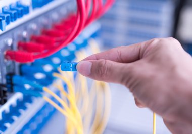 Dijital iletişim ve internet için fiber optik merkezi olan ağ sunucu odasında çalışan adam