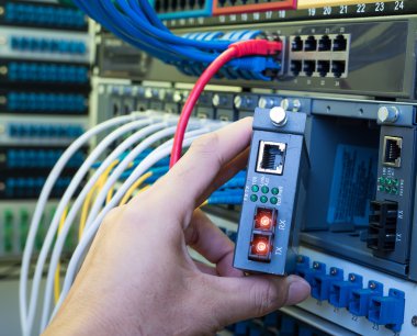 Dijital iletişim ve internet için fiber optik merkezi olan ağ sunucu odasında çalışan adam