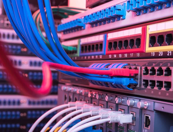 Network cables and hub closeup with fiber optical background — Stock Photo, Image