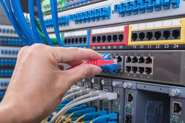 Man working in network server room with fiber optic hub for digi — Stock Photo, Image