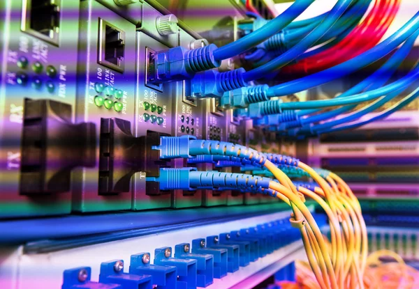光ポートに接続された光ファイバーケーブルとイーサネットポートに接続されたネットワークケーブル — ストック写真
