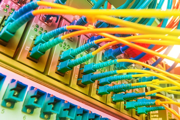 Włókna światłowodowe kable podłączone do optycznych portów i kabel sieciowy — Zdjęcie stockowe