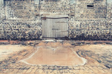 Kapısı olan eski ahşap bir duvar.