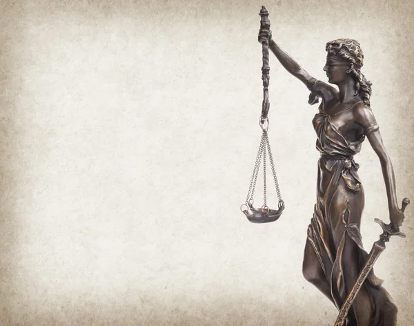 Standbeeld van Justitie op oud papier achtergrond, wet concept — Stockfoto