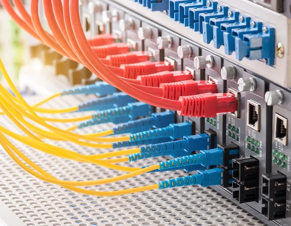 Fiber Optic cables connected to an optic ports and Network cables connected to ethernet ports