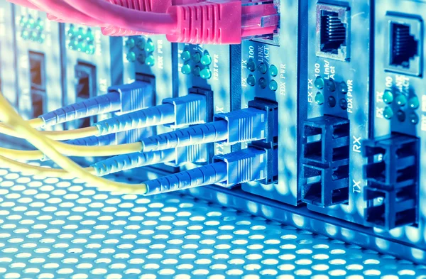 Fiber Optic cables connected to an optic ports and Network cables connected to ethernet ports