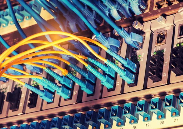 Fiber Optic cables connected to an optic ports and Network cables connected to ethernet ports