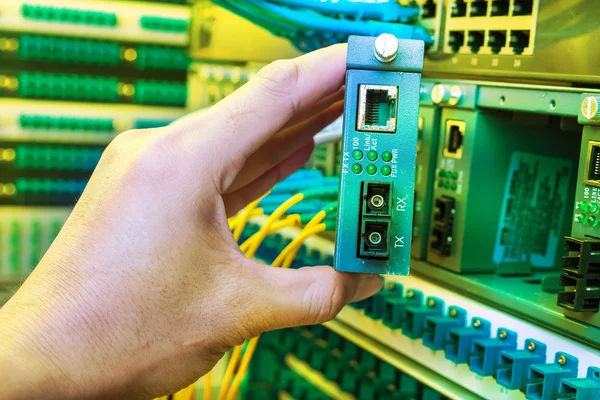 Man aan het werk in serverruimte netwerk met vezel optische hub voor digi — Stockfoto