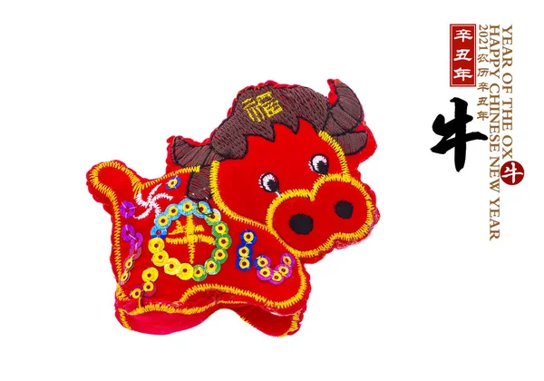 Geleneksel Çin bez bebek öküzü 2021, öküz yılı, sağ tarafta Çince karakterler ve sözcük anlamı: Yılın Çince takvimi. Öküz ve kırmızı mühür kelimesi iyi dilekler demektir.
