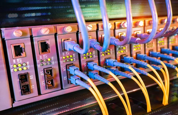 光ポートに接続されている光ファイバーケーブルとイーサネットポートに接続されているネットワークケーブル — ストック写真
