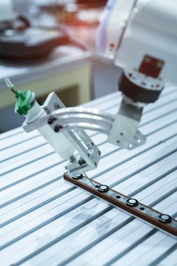 Robot tutkal şırıngasını fabrikada tutuyor.