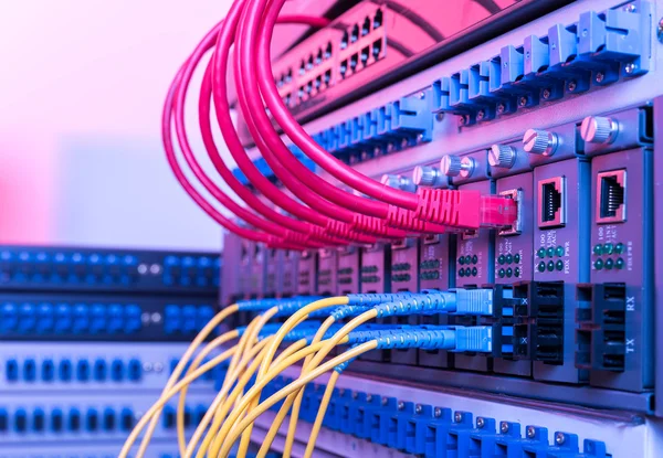 Cabos de fibra óptica e cabos de rede UTP conectados a portas de cubo . — Fotografia de Stock