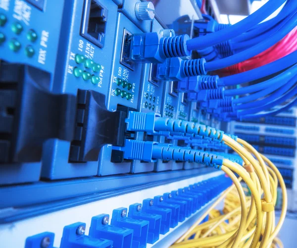 Fiber Optic cables connected to an optic ports and Network cable — Stock Photo, Image