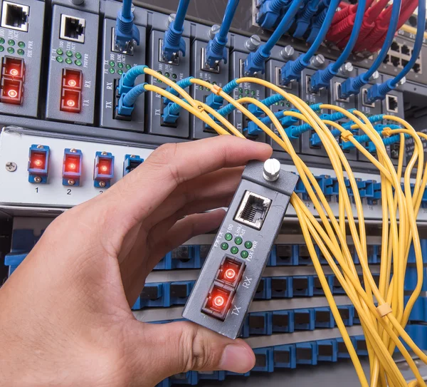 Man som arbetar i nätverk serverrum med fiber optic nav för digi — Stockfoto