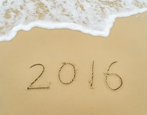 Año 2016 mano escrita en la arena blanca frente al mar —  Fotos de Stock