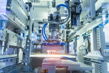 Pnömatik robotik kol üretim hattındaki ürün parçalarını topluyor. Robotik sistem tarafından yüksek teknoloji materyal işleme süreci.