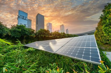 Gün batımında kentsel peyzaj simgeleri ile Ekolojik enerji yenilenebilir güneş paneli tesisi