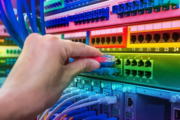 Homem trabalhando na sala de servidor de rede com hub de fibra óptica para digi — Fotografia de Stock