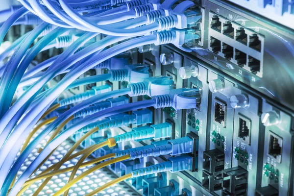 Cables de fibra óptica conectados a puertos ópticos y cable de red — Foto de Stock