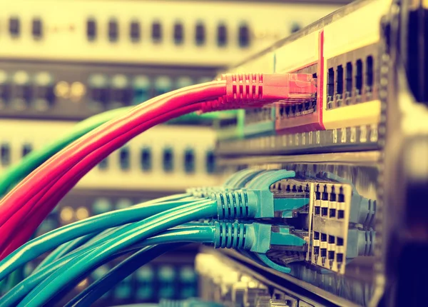 Network cables and hub closeup with fiber optical background — Stock Photo, Image