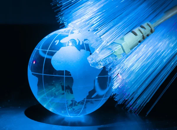 Glas jorden med nätverket mot fiber optic bakgrund — Stockfoto