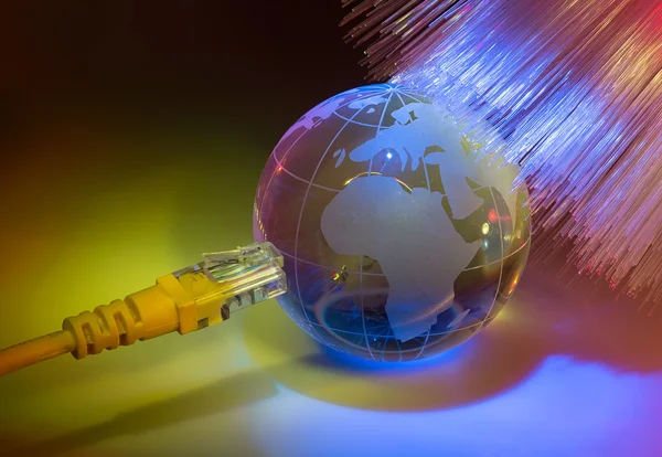 Glass earth with network against fiber optic background Royalty Free Stock Photos