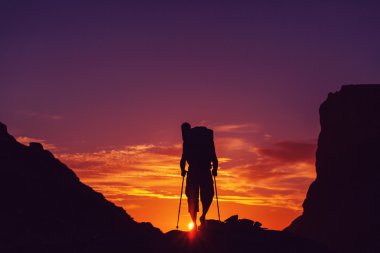 Uzun yürüyüşe çıkan kimse'nın siluet günbatımı üzerinde