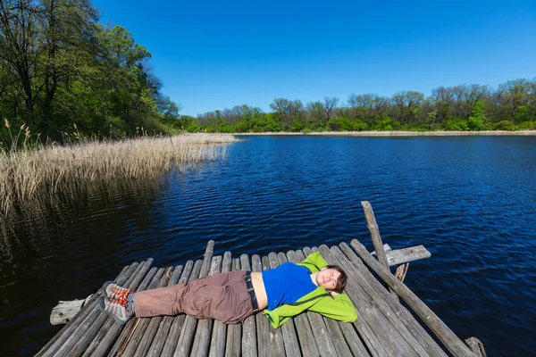 Mujer descansando junto al lago — Foto de Stock