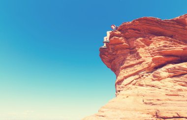 Cliff üzerinde oturan adam