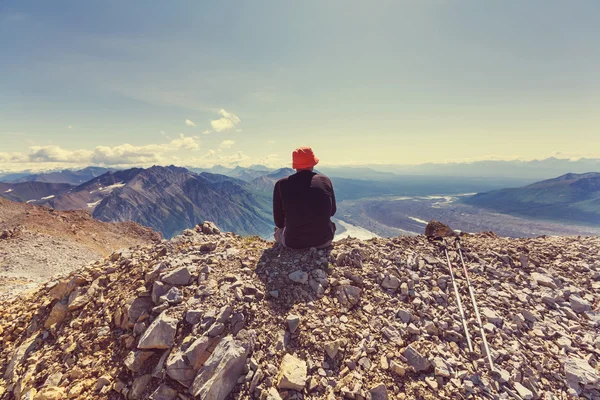 Человек сидит на скале — стоковое фото