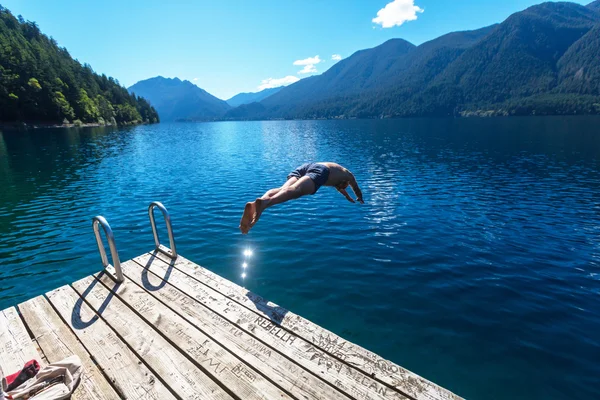 Man jumping into Lake Crescent — Stock Photo, Image