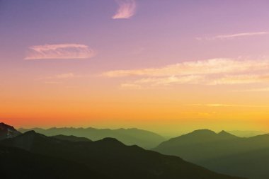 Gün doğumunda sisli dağ silueti